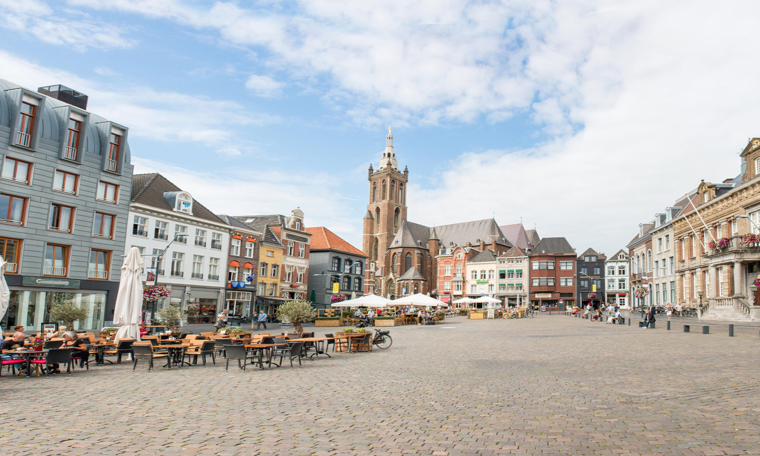 Een sfeervol beeld van het centrum van Roermond, met historische gebouwen en het imposante stadhuis prominent aanwezig op het marktplein.